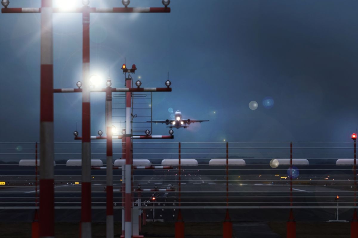 working airport beacons with starting airplane in the evening